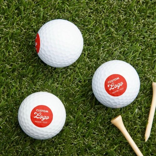 Custom logo golf balls on grass.